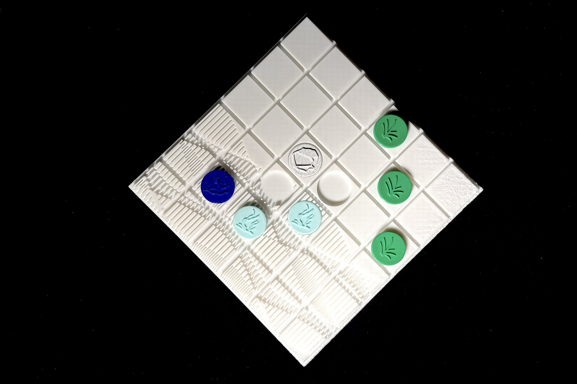 A white 3D-printed Tidal Fields game board with colored playing pieces